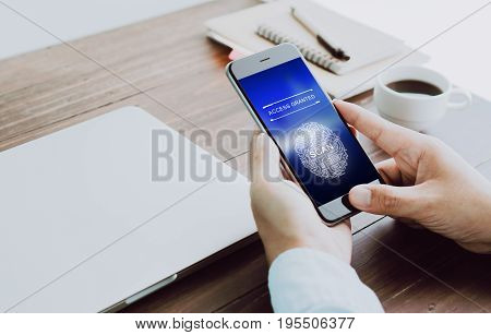 The hand is scanning biometric fingerprints for approval to access electronic devices. The concept of the danger of using electronic devices is important.