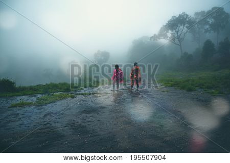 Lover Men and women Asia travel relax. walk in the forest rainy season. puhinrongkla Thailand