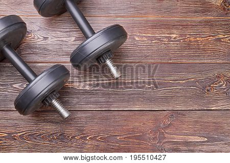 Weight lifting objects on wooden floor. Metal equipment for heavy fitness training.