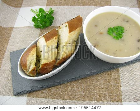 Lye baguette with herb butter and porcini mushroom cream soup