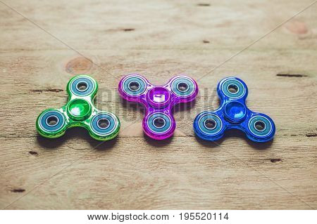 Colored Fidget Spinners Stress Relieving Toy On Wooden Background