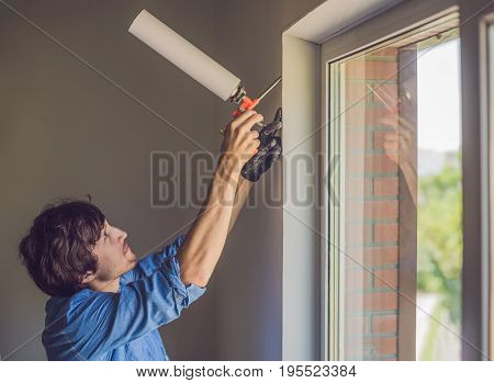Man In A Blue Shirt Does Window Installation