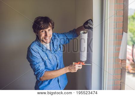 Man In A Blue Shirt Does Window Installation