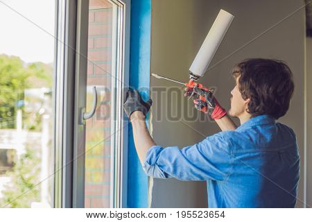 Man In A Blue Shirt Does Window Installation