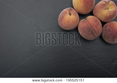Ripe Peach ion black background of slate or stone.