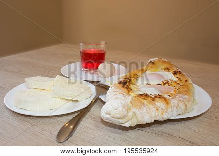 Adjarian khachapuri close-up. This traditional georgian dish contains brinsen cheese butter and row egg. Delicious homemade khachapuri in Adjarian