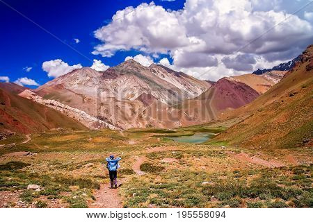 Female trekker walking alone on the trekking path to Aconcagua, highest peak in South America, Argentina