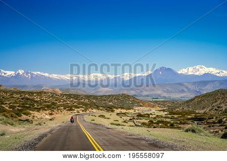 Woman cycling on the famous national Ruta 40 
 quarenta in central Argentina