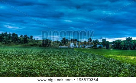 Farmhouse with corn fields tress and clouds