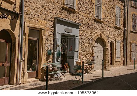 Lourmarin, France - July 07, 2016. View of typical stone houses and shops on a street of the historical village of Lourmarin. Located in the Vaucluse department, Provence region, southeastern France