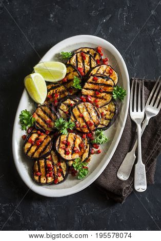 Soy sauce and ginger marinated grilled eggplant on a dark background top view. Delicious vegetarian appetizer or snack. Asian style food