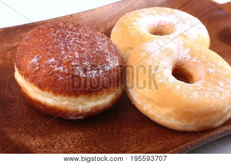 Assorted Homemade Doughnuts with Jelly filled and powdered sugar on wooden salver. Selective focus