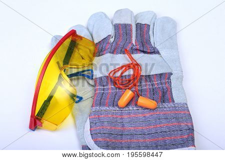 Orange earplug, safety glasses and gloves for work. Earplug to reduce noise on a white background