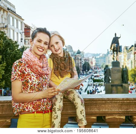 The spirit of old Europe in Prague. happy modern mother and child tourists in Prague Czech Republic with map