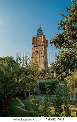 View of the clock tower made of stone on top of the hill with vegetation in the lively and gracious town of Draguignan. Located in the Var department, Provence region, southeastern France