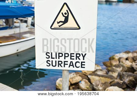 Warning: Slippery Surface sign near the sea