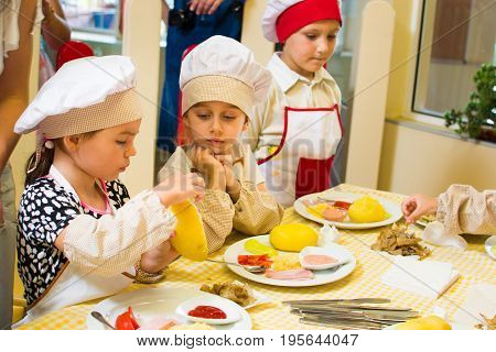 Alchevsk, Ukraine - July 16, 2017: Children's Master Class On Cooking Potatoes In The Oven With Ham 