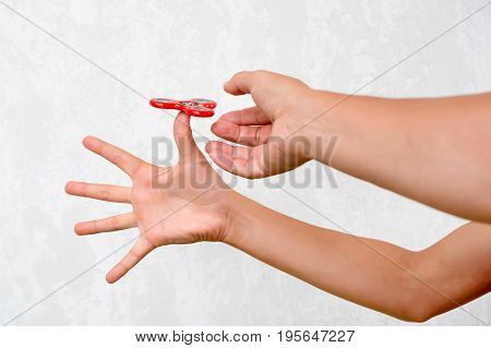 Fidget spinner. Red hand spinner, boys playing with fidgeting hand toy. Stress relief. Anti stress and relaxation adhd attention fad boy concept
