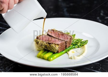 medium done grilled tuna steak with asparagus served on the asparagus and mashpotato