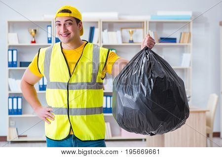 Man cleaning the office and holding garbage bag
