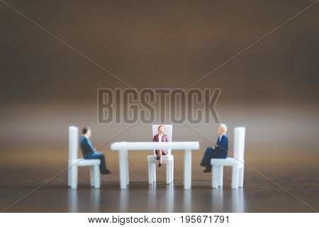 Miniature People Team Sitting Down On The Chair