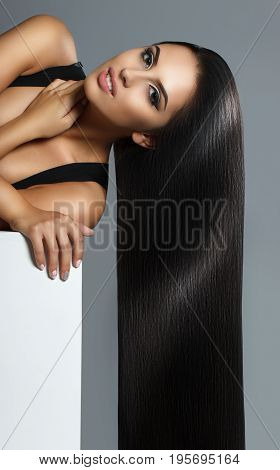 Creative Portrait Of A Beautiful Brunette Model. The Girl Is Posing In The Studio. Long Perfect Hair