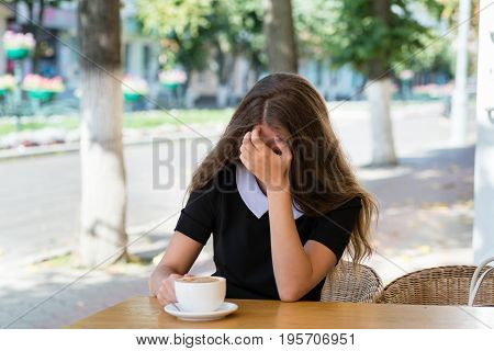 Young businesswoman is stressed at a sidewalk cafe
