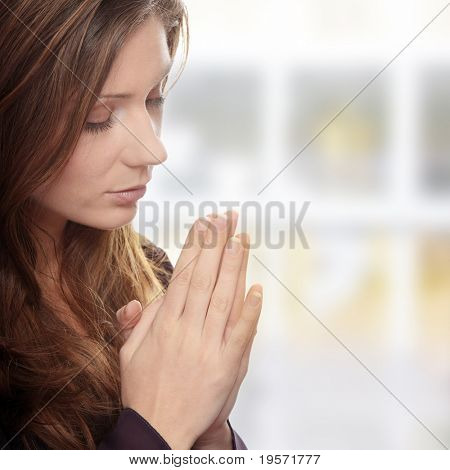 Closeup portrait of a young caucasian woman praying