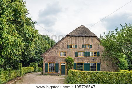 Abandoned thatched monumental farm with green shutters in a small village in the Netherlands. The farmhouse was built in 1850.