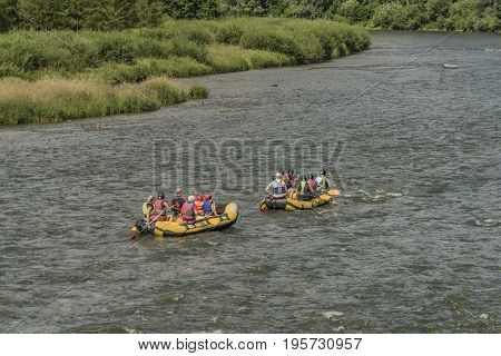Boats on river Dunajec after rain with blue water and funny people
