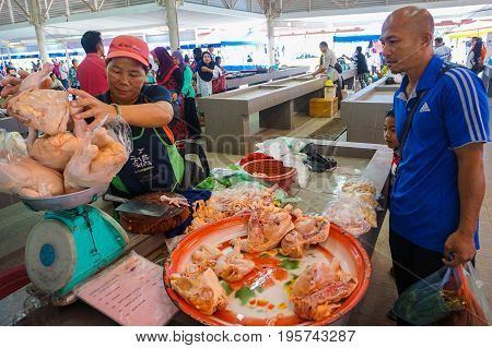 Keningau,Sabah,Malaysia-June 29,2017:Local man buy chicken meat at the local market Tamu in Keningau,Sabah.Its a place where all farmers,fishermen & vendors gathers weekly to sell their products