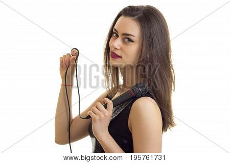 Charming brunette woman in elegnat black dress with microphone isolated on white background