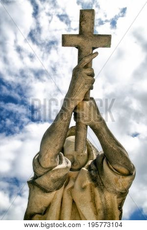 BUDAPEST HUNGARY - MAY 8: Statue with catholic cross in hands at Kerepesi - historic cemetery on May 8 2017 in Budapest