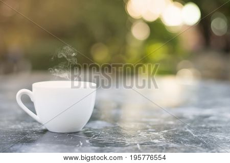 White cup morning coffee in garden and sunrise.