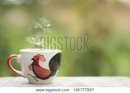 White cup morning coffee in garden and sunrise