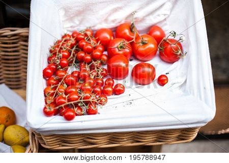 Ripe red tomatoes on a market stall close up. Summer tray market agriculture farm full of organic tomatoes. Fresh tomatoes.