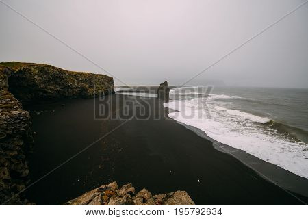 Black beach Kirkjufjara during the storm on Atlantic ocean.