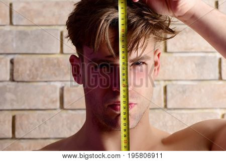 Guy With Builders Ruler Near Brick Wall. Worker With Roulette