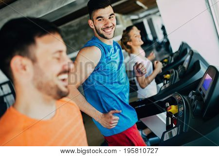 Group of friends exercising on treadmill machine in gym