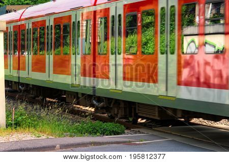 S-Bahn train passes a restricted railway crossing.
