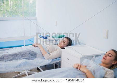 Female patient sleeping in medical bed at the hospital ward.
