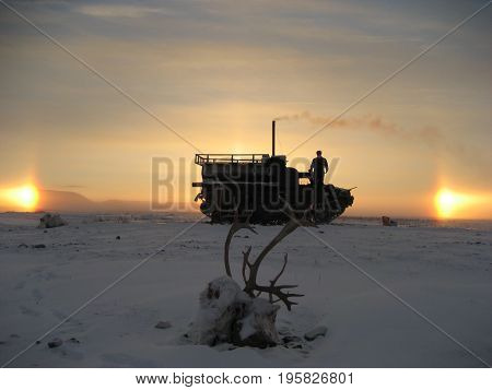 Taimyr. Winter tundra. Hunting for the reindeer. Cross-country vehicle and two suns.