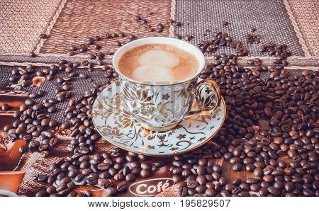 Cup of morning fresh fragrant coffee on a table with grains