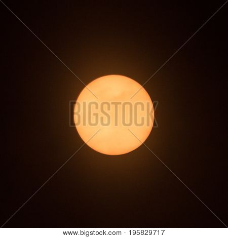 Sun with sunspot at 3 o'clock position with clouds