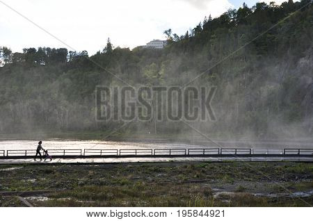 Mother pushes cart among the mist in Montmorency, Quebec