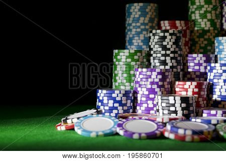 Stack of Poker chips on a green gaming poker table at the casino. Poker game concept. Playing a game with dice. Casino Concept for business risk chance good luck or gambling. chips for poker game
