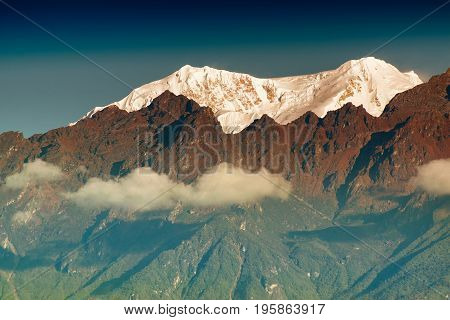 Beautiful first light from sunrise on Mount Kanchenjugha Himalayan mountain range Sikkim India. Orange tint on the mountains at dawn