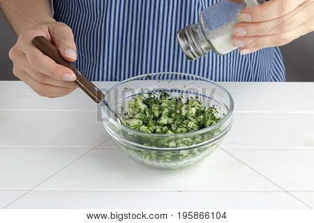 Step By Step Recipe For Tarator. Hands Salted Mixed Vegetables In A Bowl.