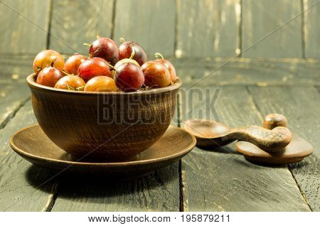A Multicolored Gooseberry In Clay Dishes. Warm Mood.