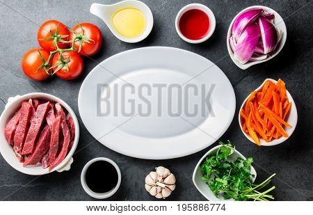 Ingredientes For Cooking Peruvian Dish Lomo Saltado - Tenderloin Beef, Vegetables Around White Plate